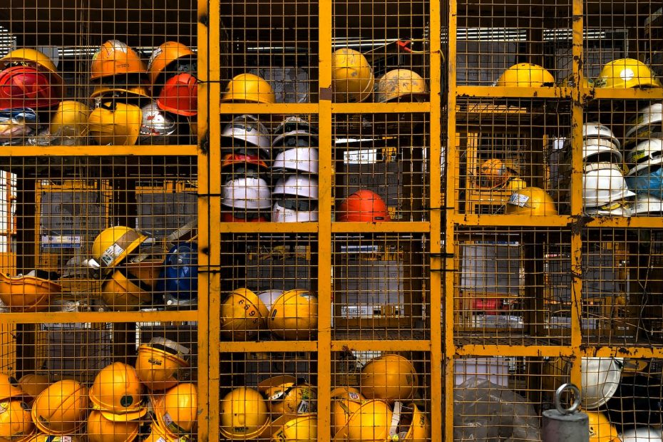 a rack filled with lots of yellow hard hats